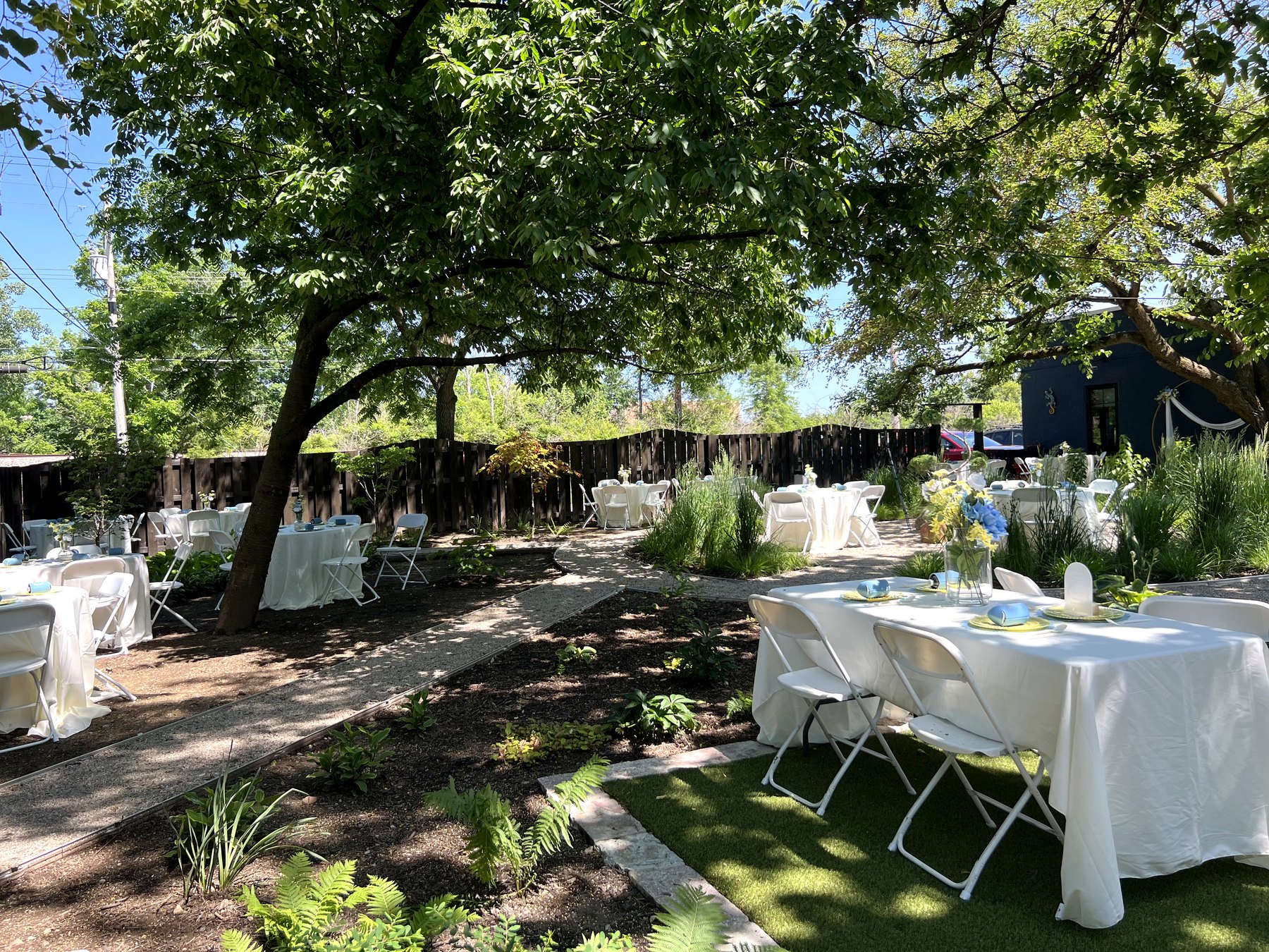 Outdoor event tables under trees at Indigo Sun